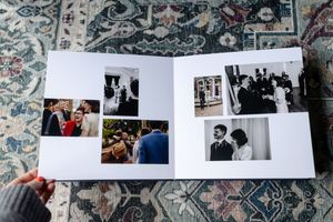 A collection of black and white and color photographs arranged in an album against a floral patterned background.
