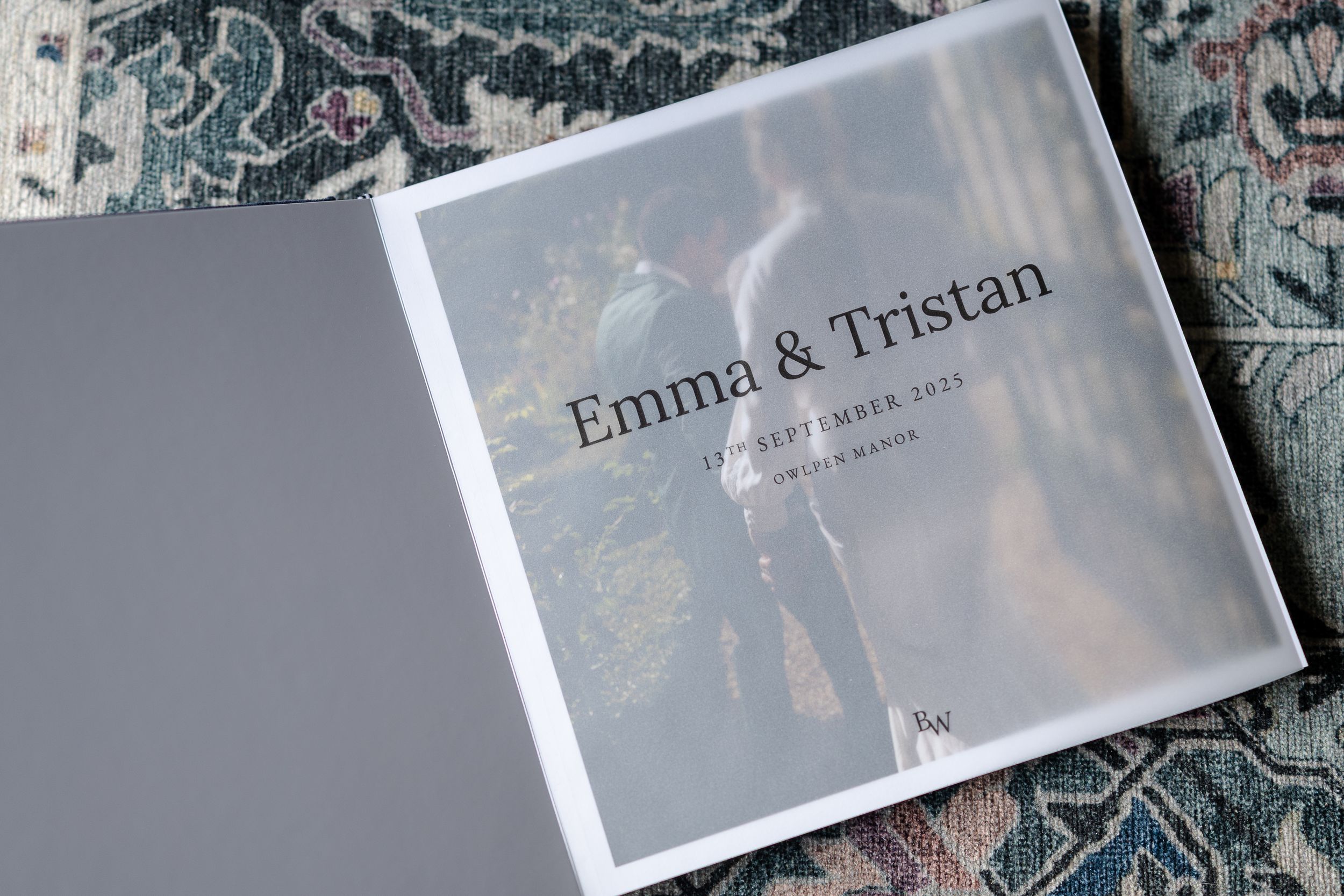 A wedding photo album with multiple pages showing black and white photographs laid out on a textured surface.