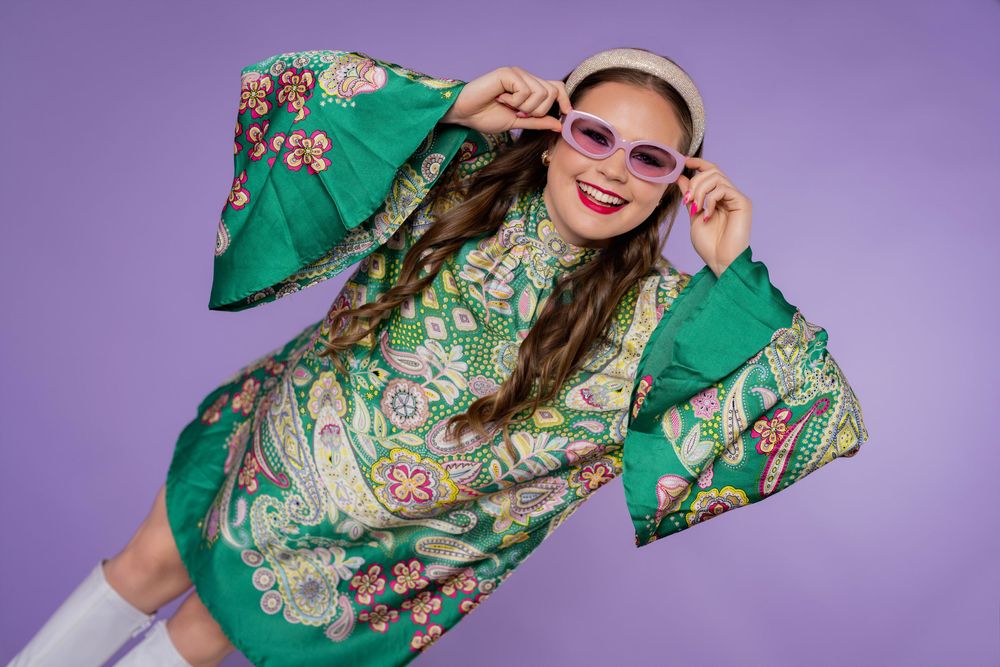 A fashion model poses in a vibrant green floral dress against a purple background in a photo collage.