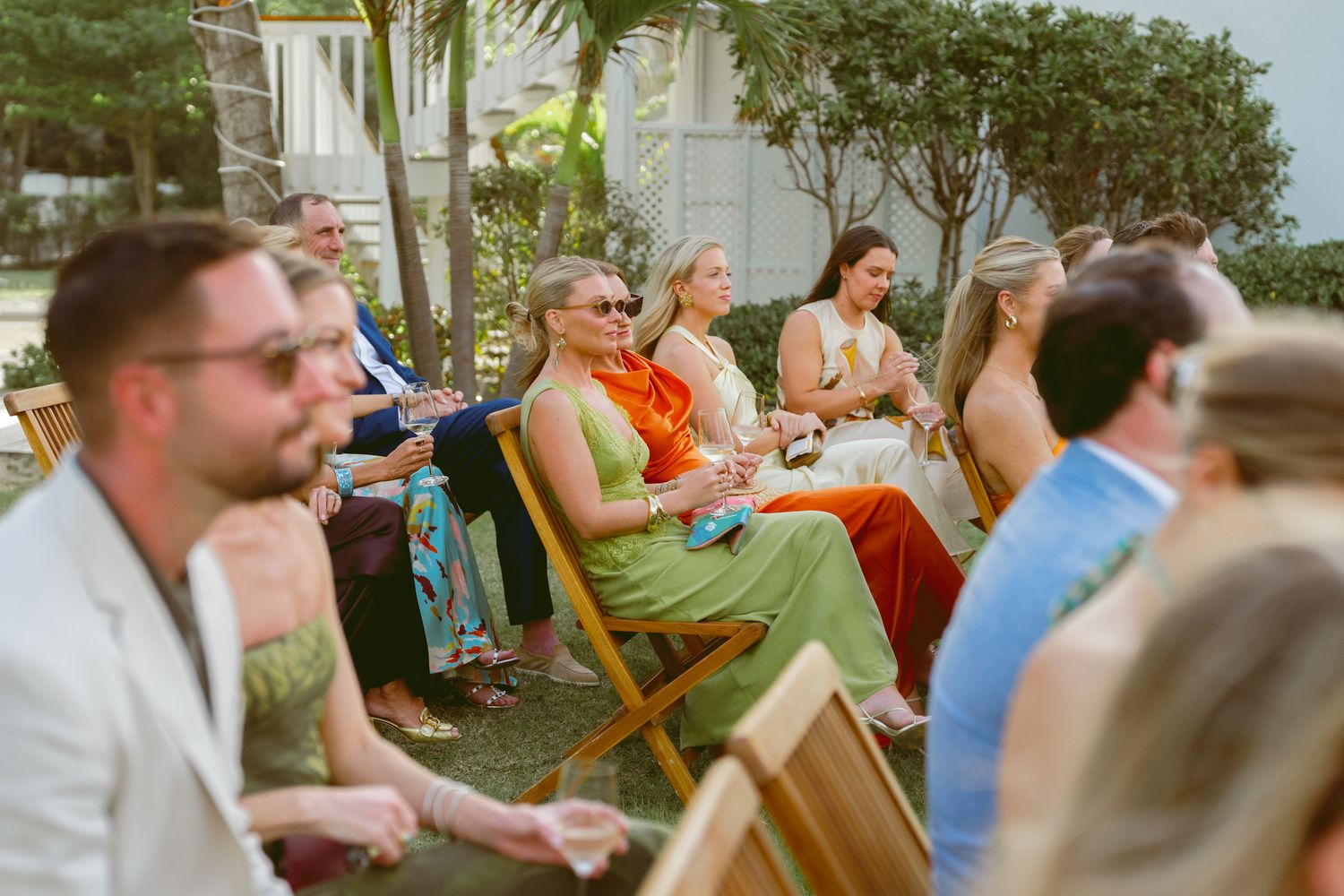 Wedding guests enjoying an outdoor reception with orange and blue color scheme.