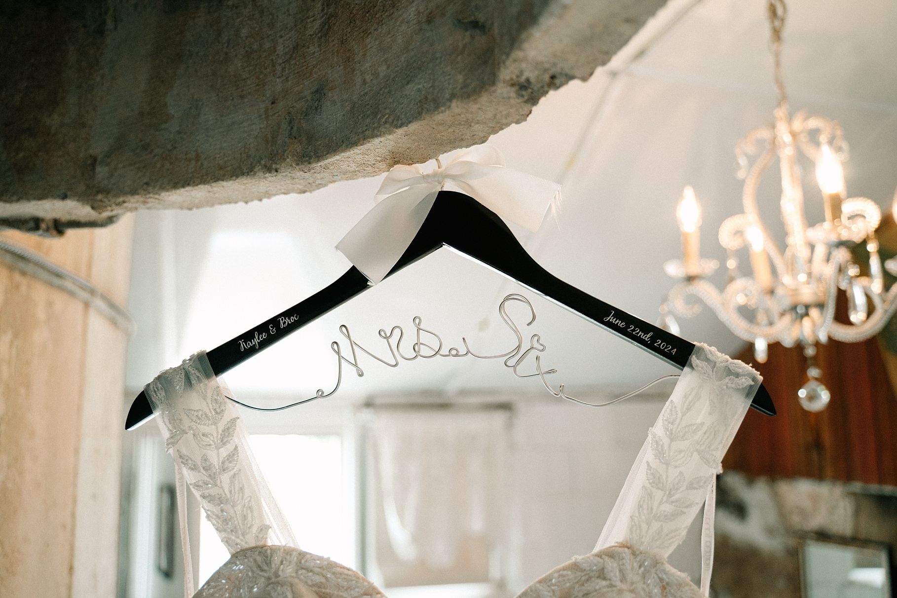 Custom personalized black wedding dress hanger with bride and groom names in script.