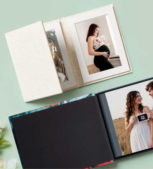 Black framed photo display showing a romantic moment with string lights in the background.