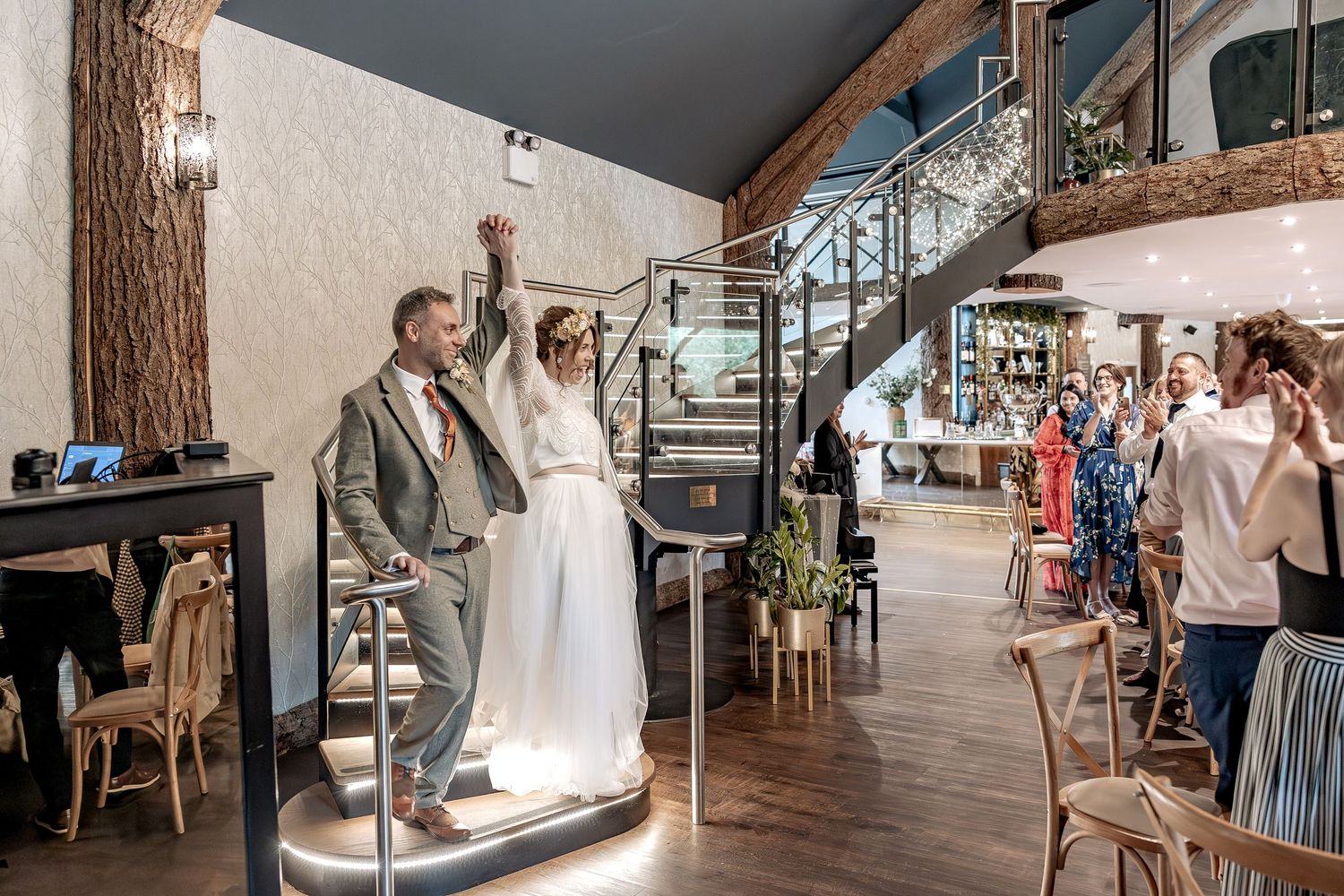 Unobtrusive documentary wedding photo of newlyweds and guests reactions as they enter their wedding breakfast.