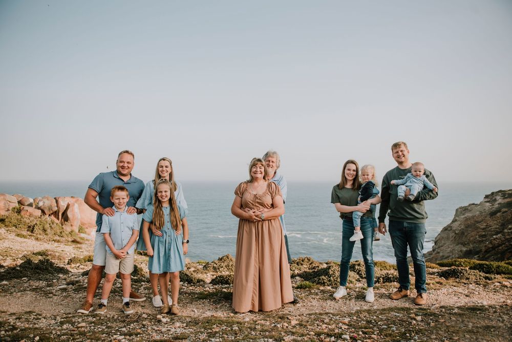 Extended family photograph taken at St Blaize with a scenic coastal backdrop, capturing a warm and memorable group portrait