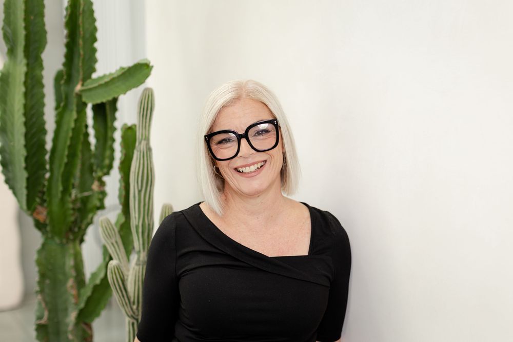 Professional headshots against white wall with tall green cactus plants in modern minimalist style.