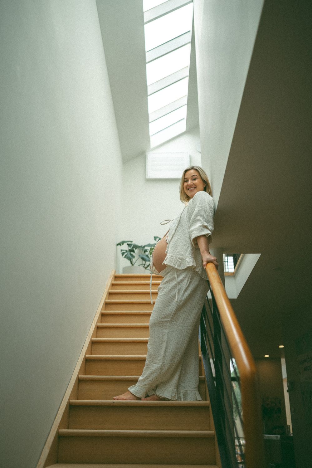 A sequence of photos showing someone walking down wooden stairs in a modern interior with white walls.