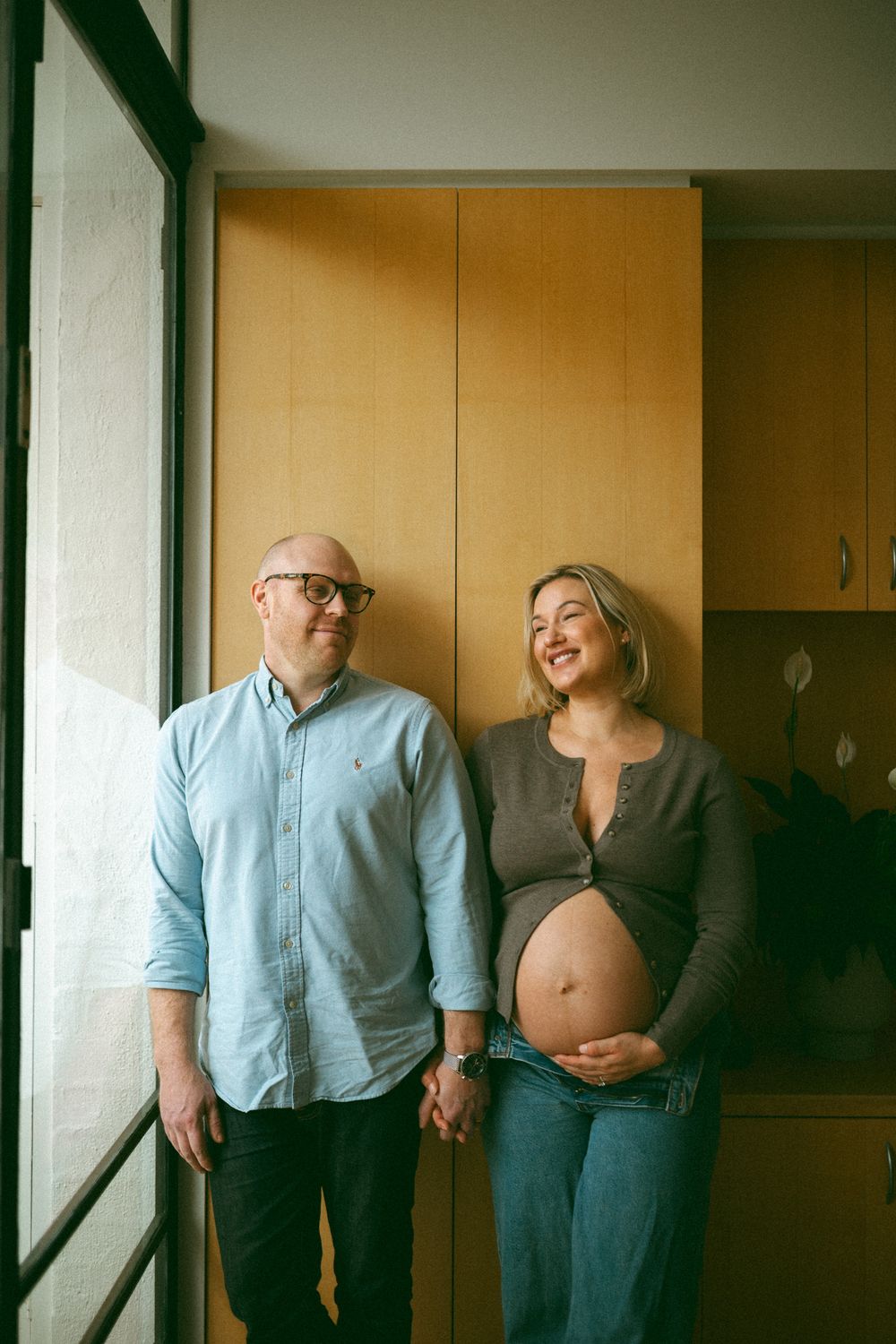 A series of photos showing a couple's pregnancy progression through candid moments in a home setting.