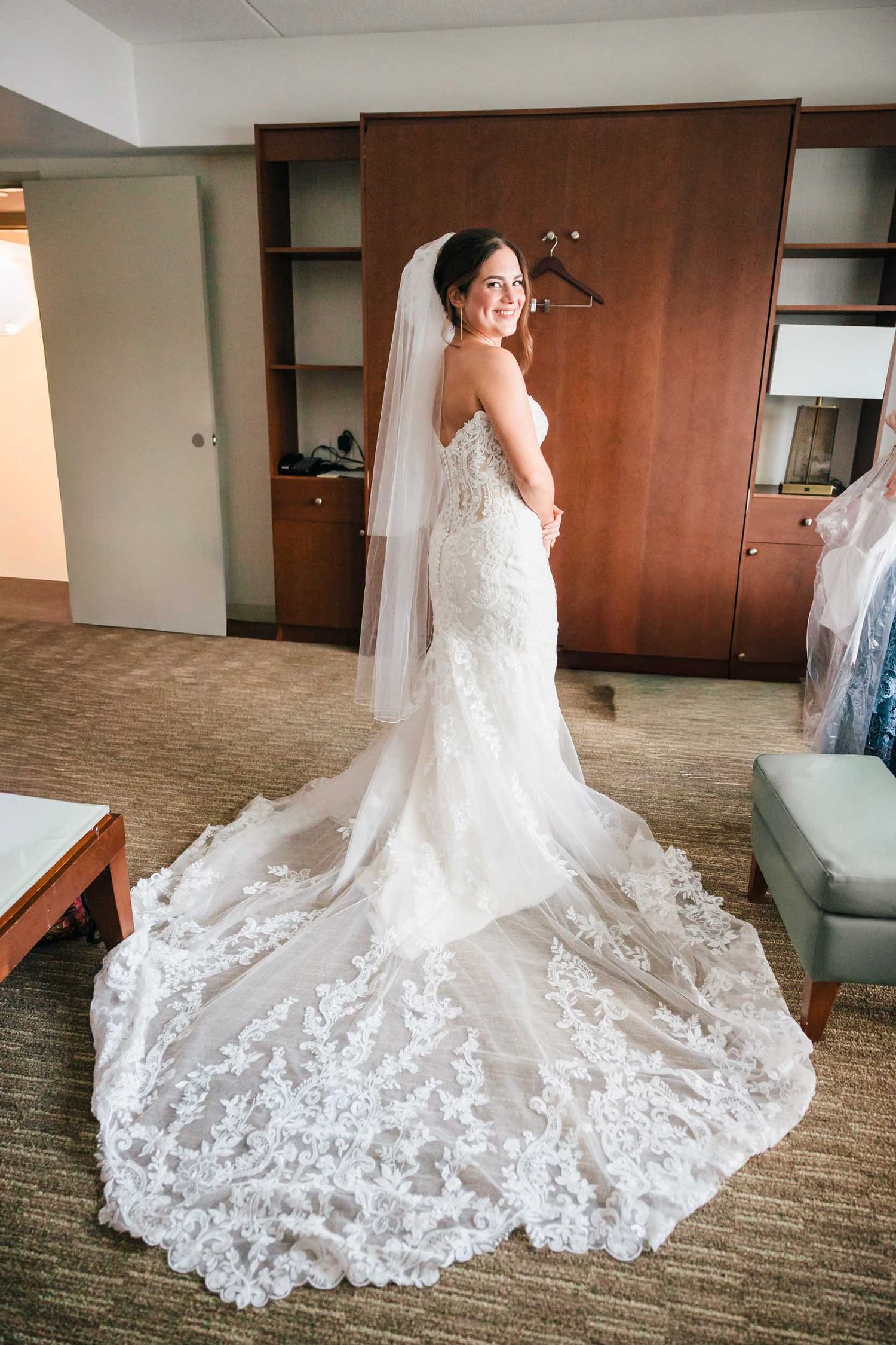 Bride posing in her lace wedding dress and veil during wedding preparations in Boston