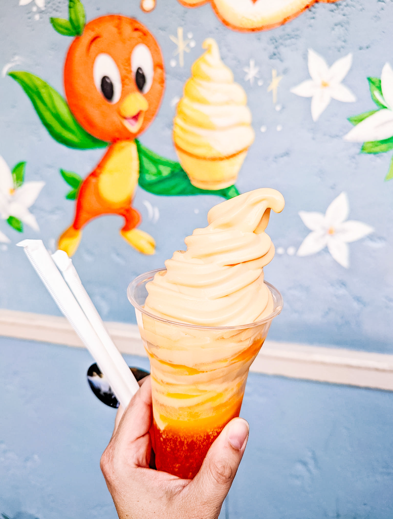 Orange and peach colored ice cream swirls topped with magical flower decorations and an orange character.