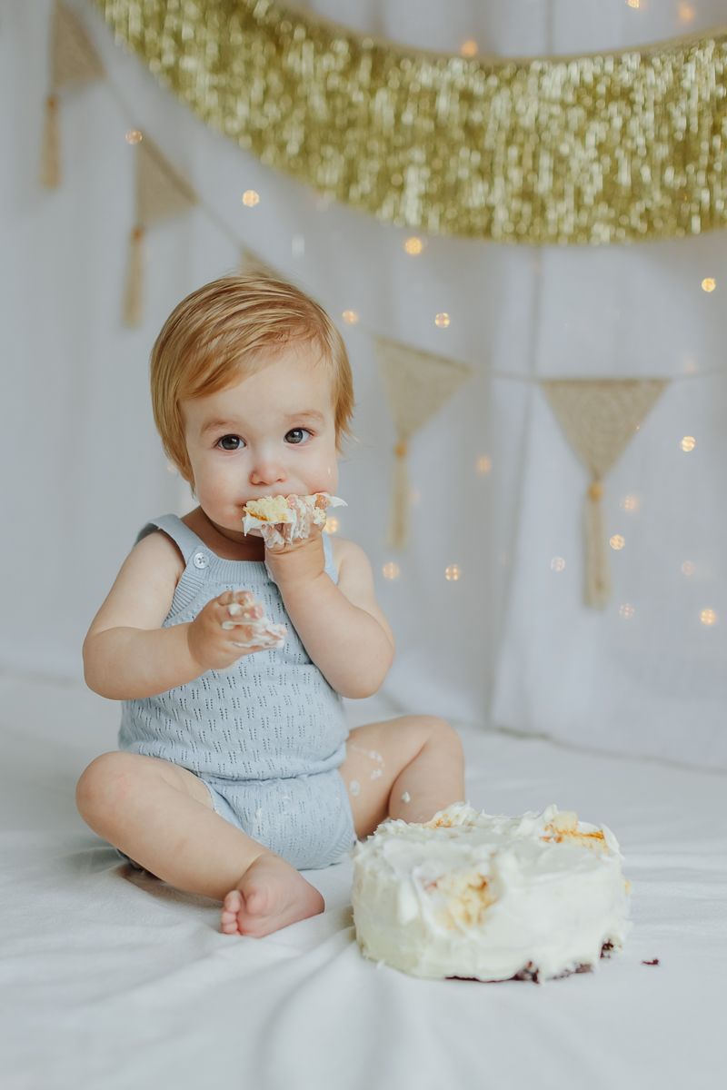 1st birthday boy taking a big bite of chocolae cake