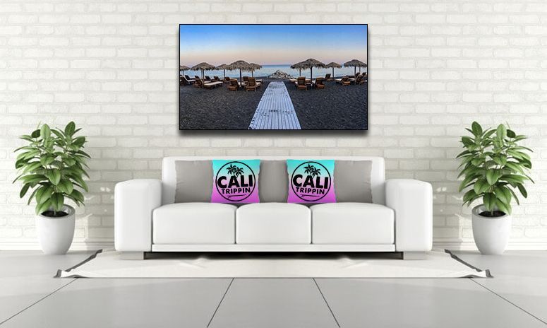 Fine art beach photography canvas print displayed in a home office above a white sofa with CaliTrippin pillows.