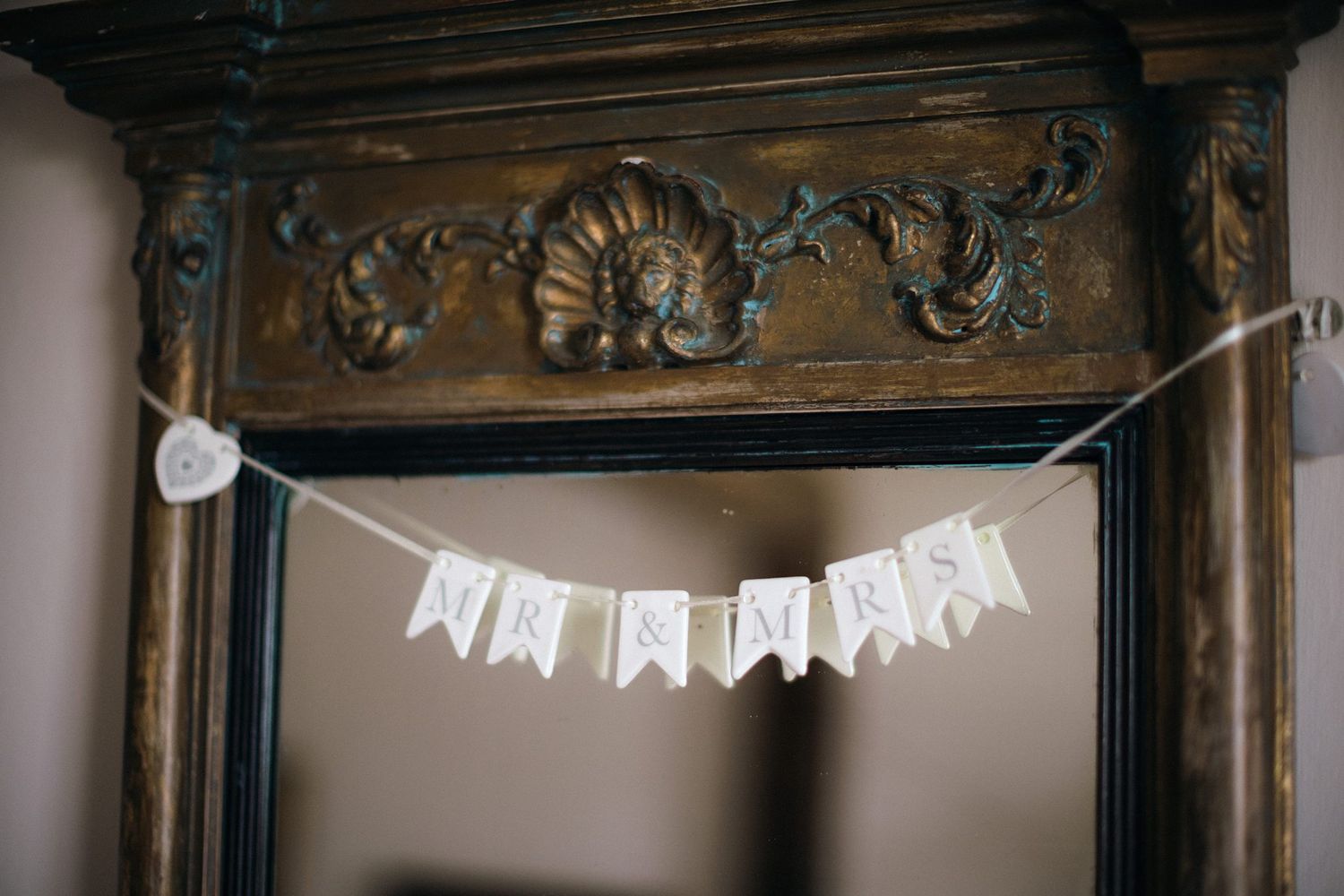 White fabric banner with 'MR & MRS' text hangs from an ornate wooden frame at Healy Events with carved details.