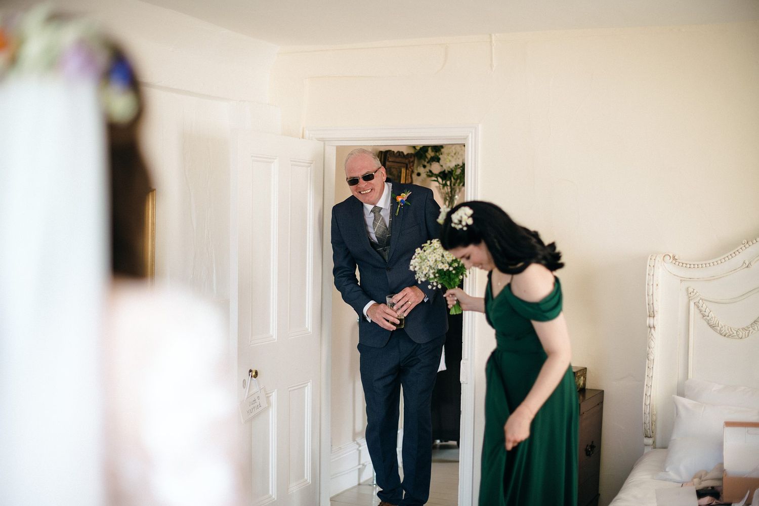 A couple standing in a doorway seeing the bride for the first time at Healy Events wedding venue, Nova Scotia.