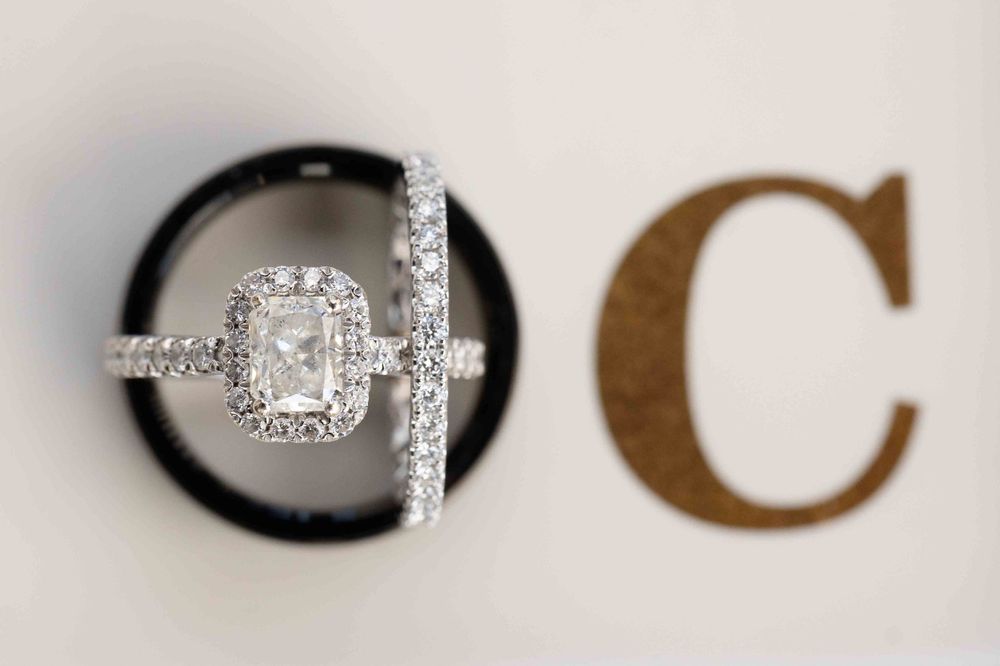 A sparkling diamond engagement ring photographed next to a decorative letter C.