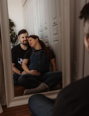 A couple shares an intimate moment while resting against white doors.