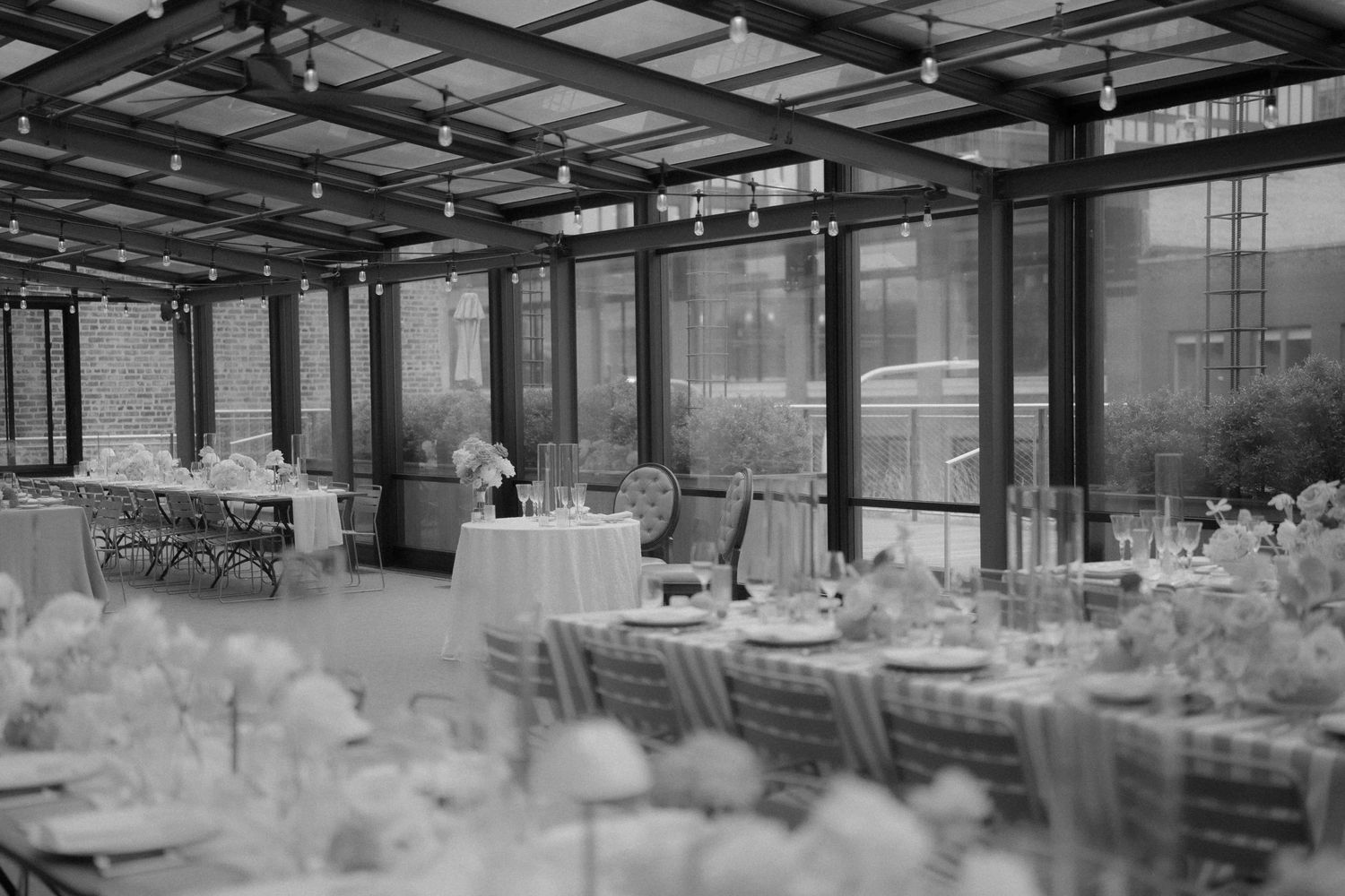 Black and White photo of dinner set up at Morgan's on Fulton showcasing guests tables and sweethearts table. Photo by: FORGET ME NOT ARTS