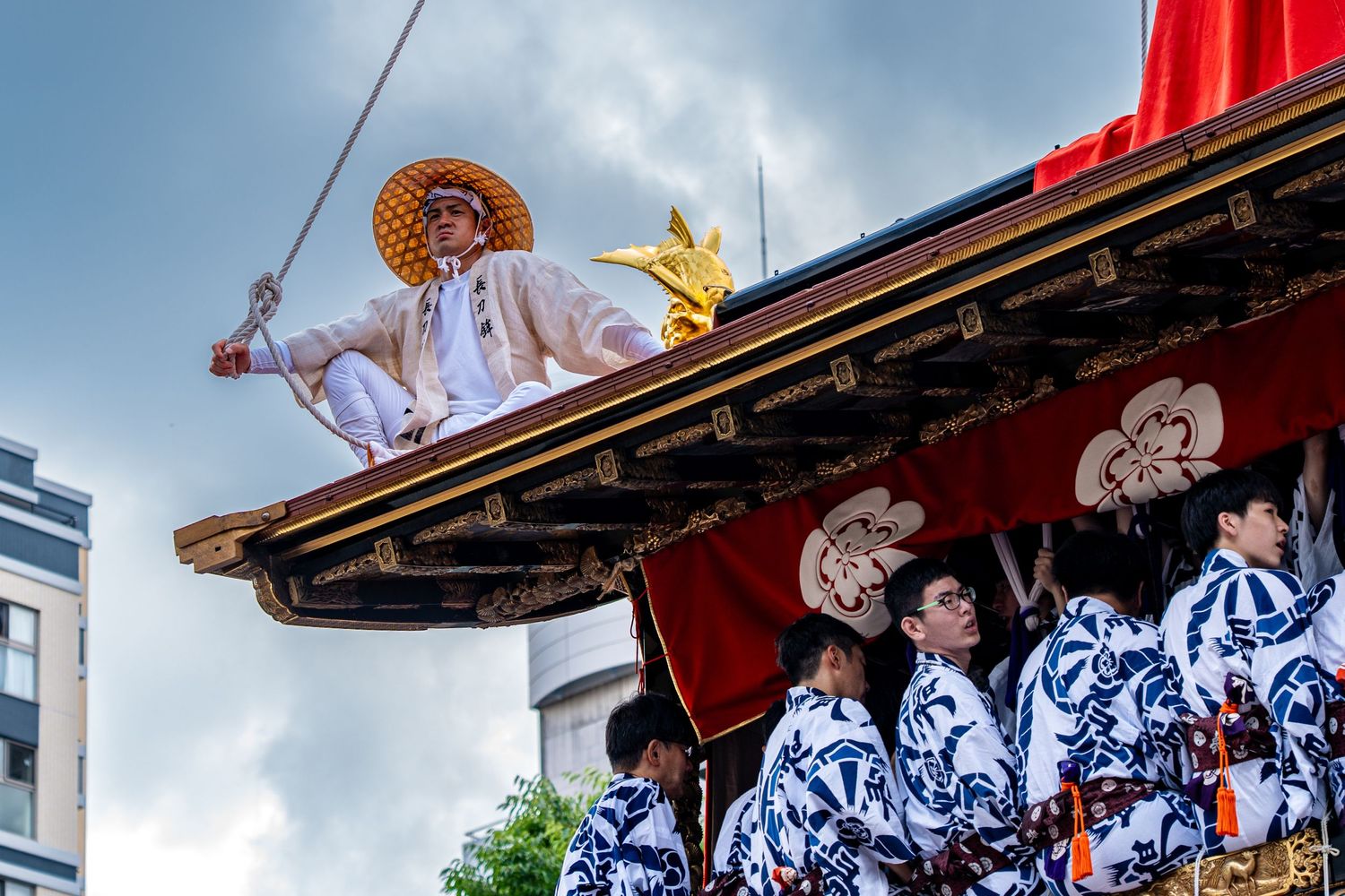 Traditional Japanese festival performers on a temple roof during a summer celebration.