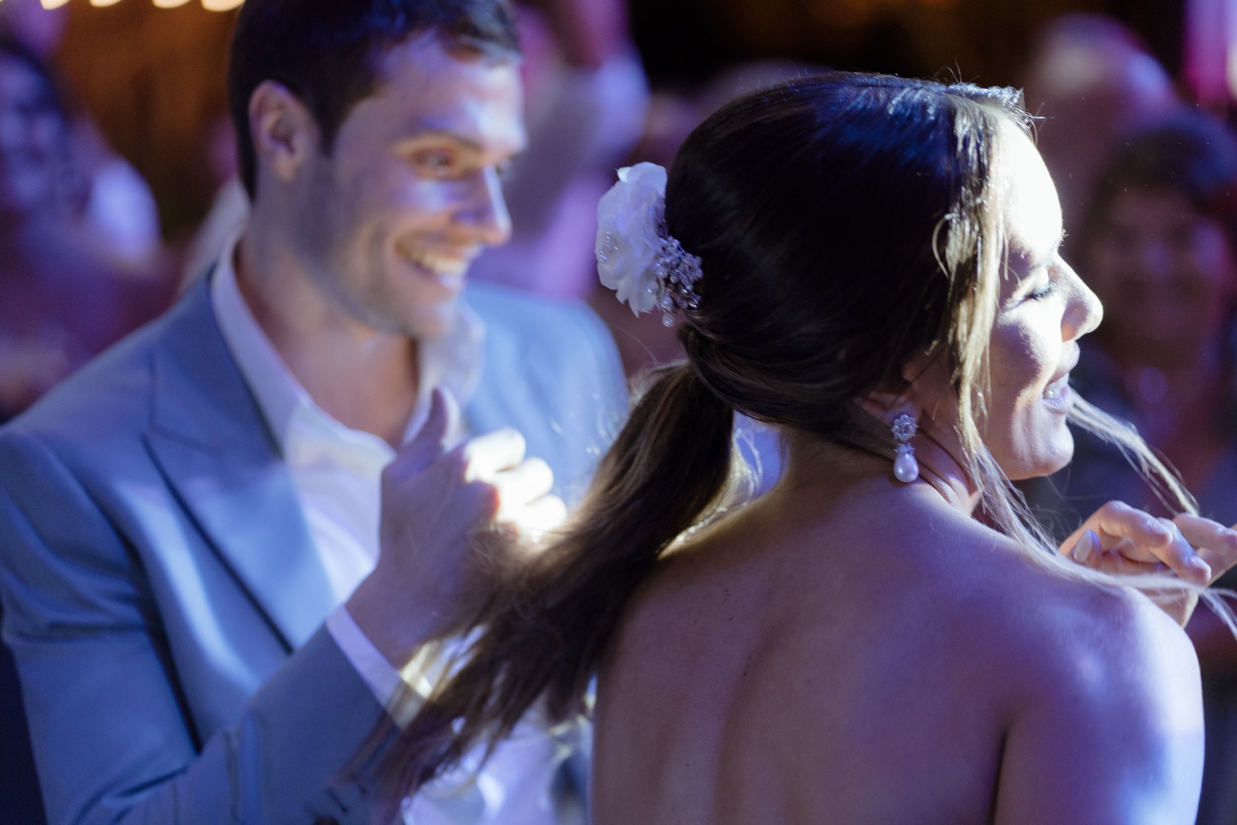 Couple sharing intimate dance moment under soft lighting at reception.