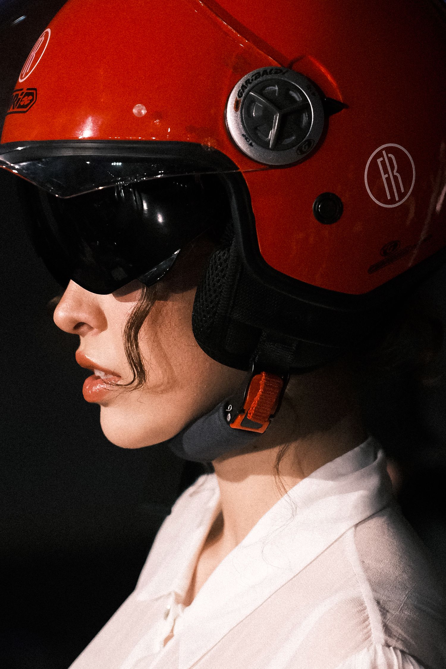 Model wearing red helmet portrait photo at milan fashion week show.