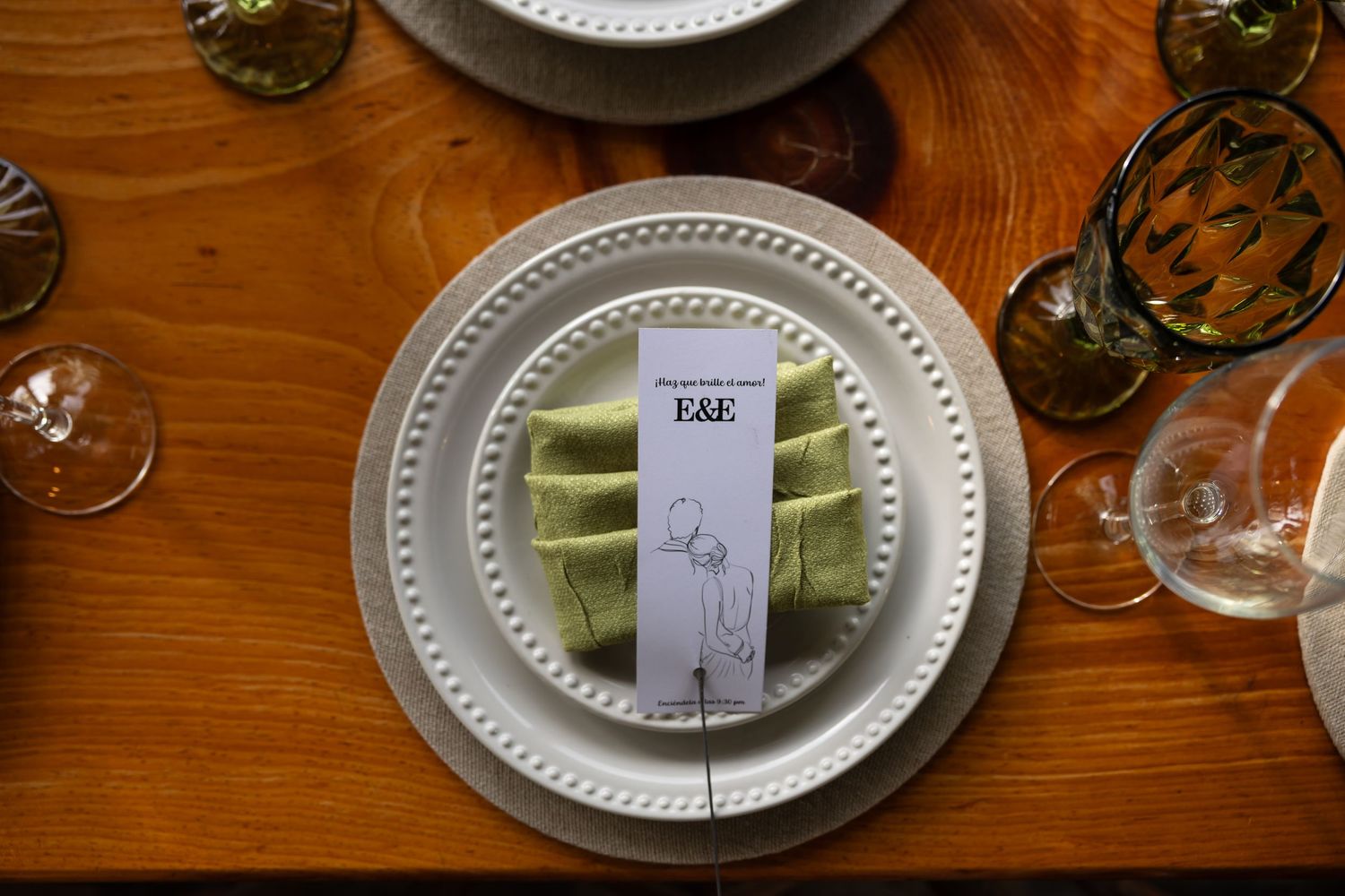 Formal place settings with white plates and name cards on a polished wooden table.