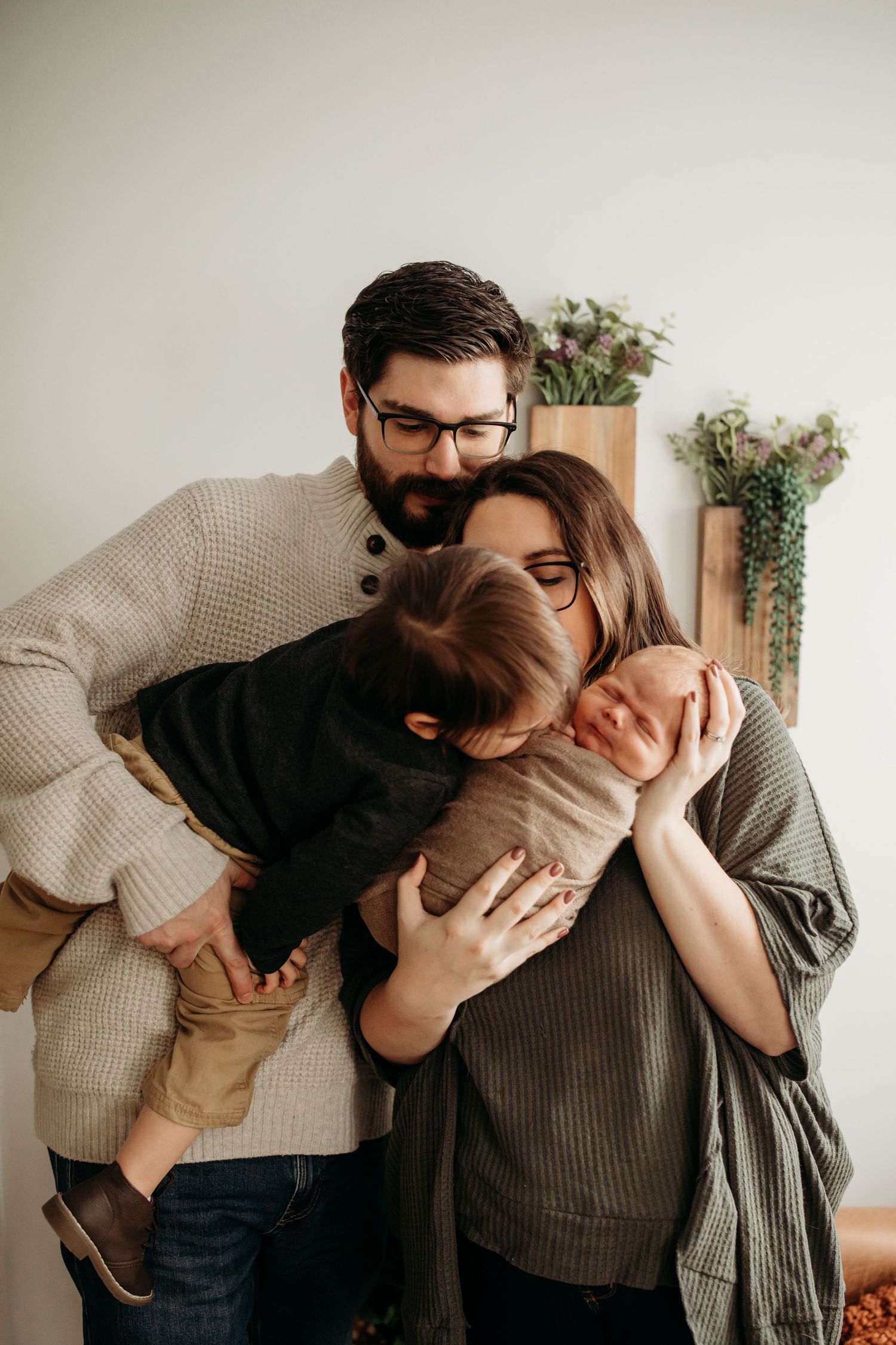 Cozy indoor scene with knit sweaters and greenery in background.