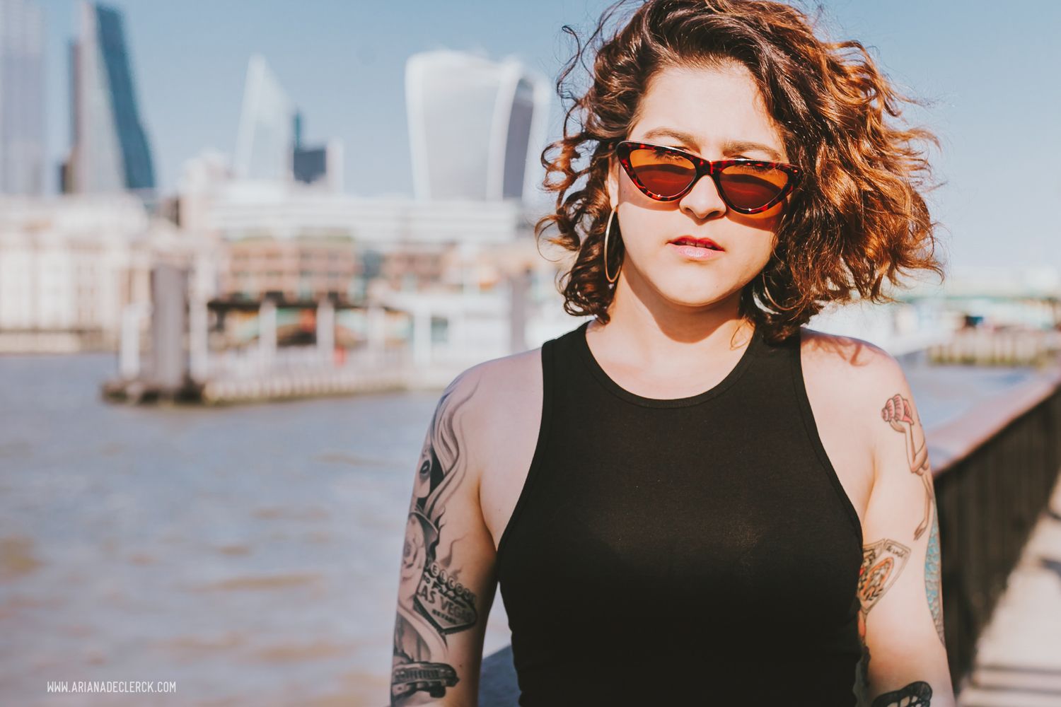 Stylish shot by the Thames River with London's modern skyline in the background.