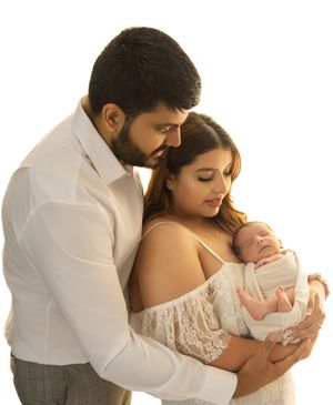 A series of tender family portraits showing parents embracing their newborn baby in white and neutral tones.