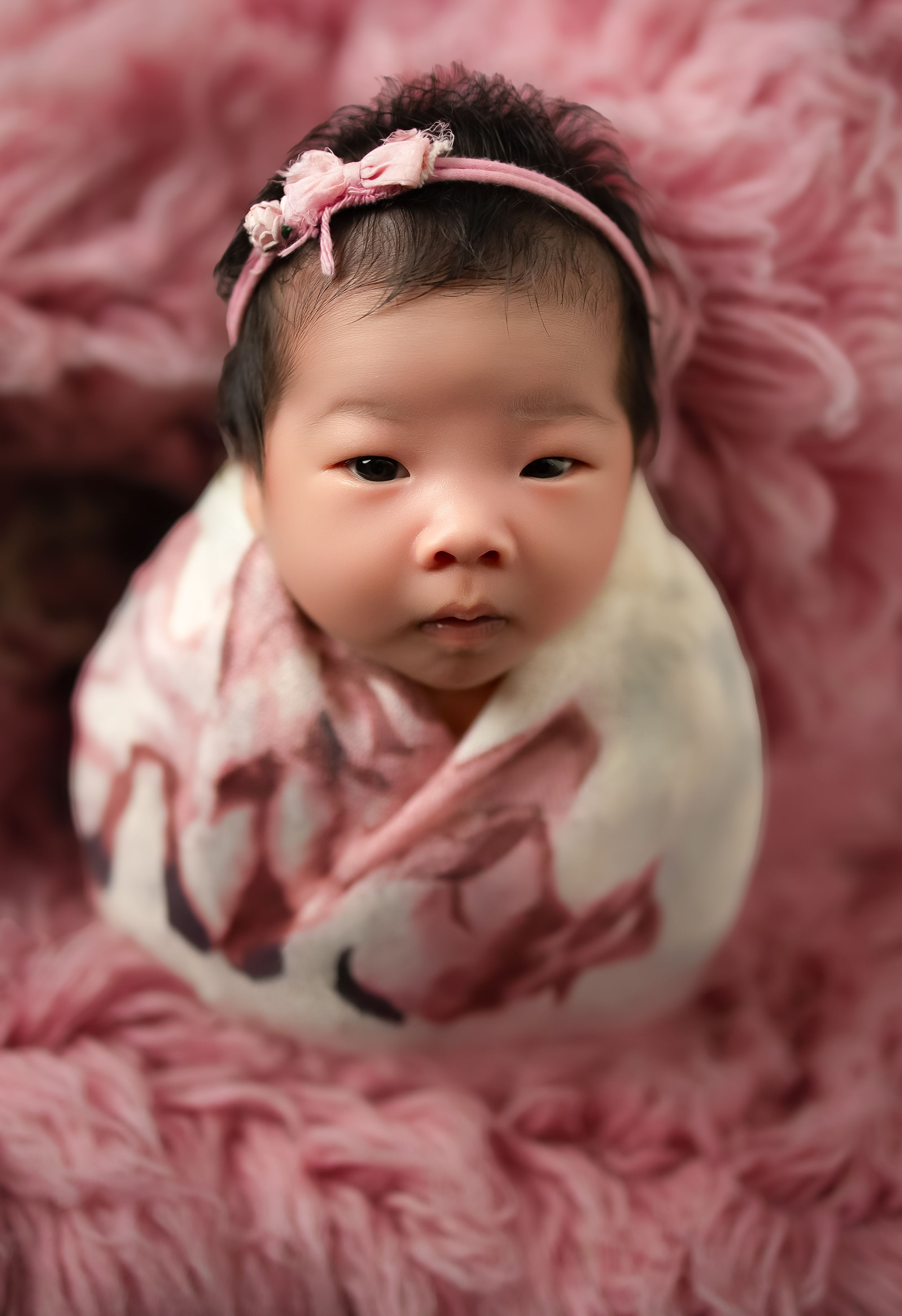 Luxury Newborn baby photoshoot, Vanessa Charlotte photography Wednesbury. Baby wearing pink floral headband on soft pink textured blanket.