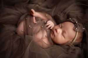 Peaceful sleeping baby wrapped in soft brown fabriC. Luxury Newborn baby photoshoot, Vanessa Charlotte photography Wednesbury by Birmingham