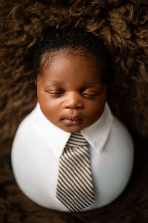 A striped necktie adorns a white collar against a dark textured background in a series of artistic photos.