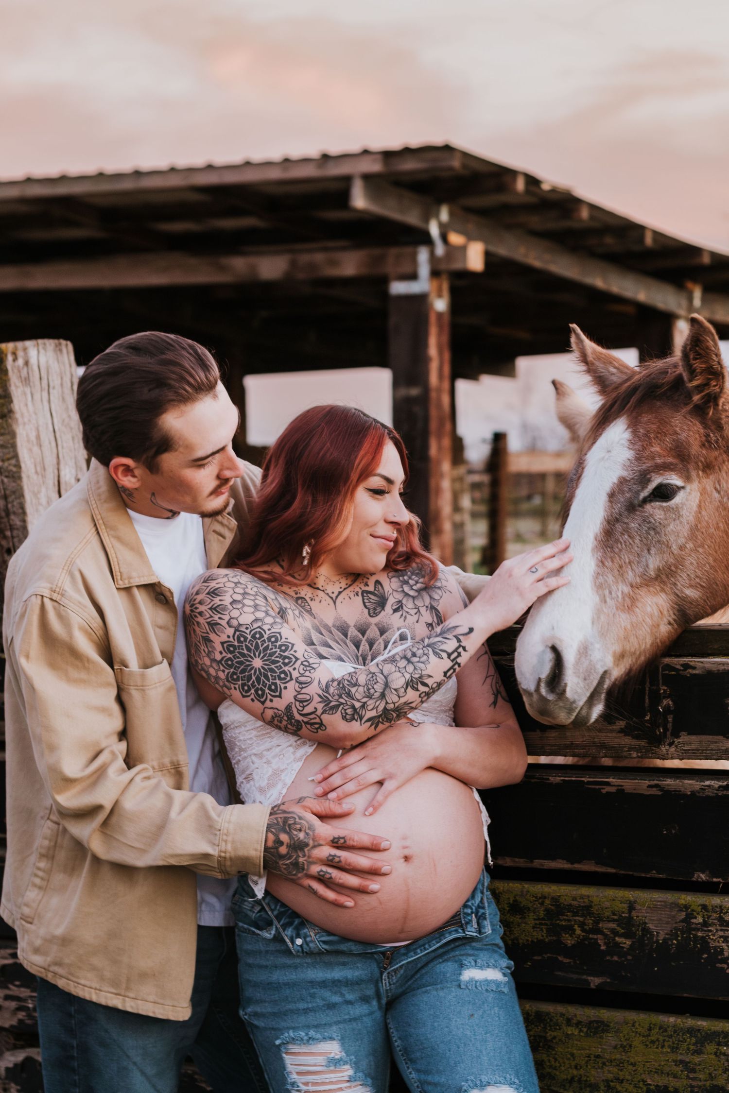 A couple poses with a horse at sunset for a rustic maternity photo shoot on a farm in Lodi.