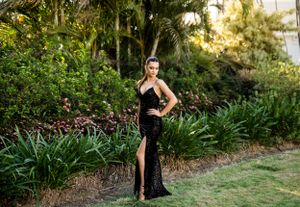 Stunning black evening gown captured in a tropical garden landscape.