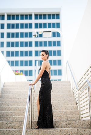 Dramatic fashion shoot on concrete stairs with modern building backdrop.
