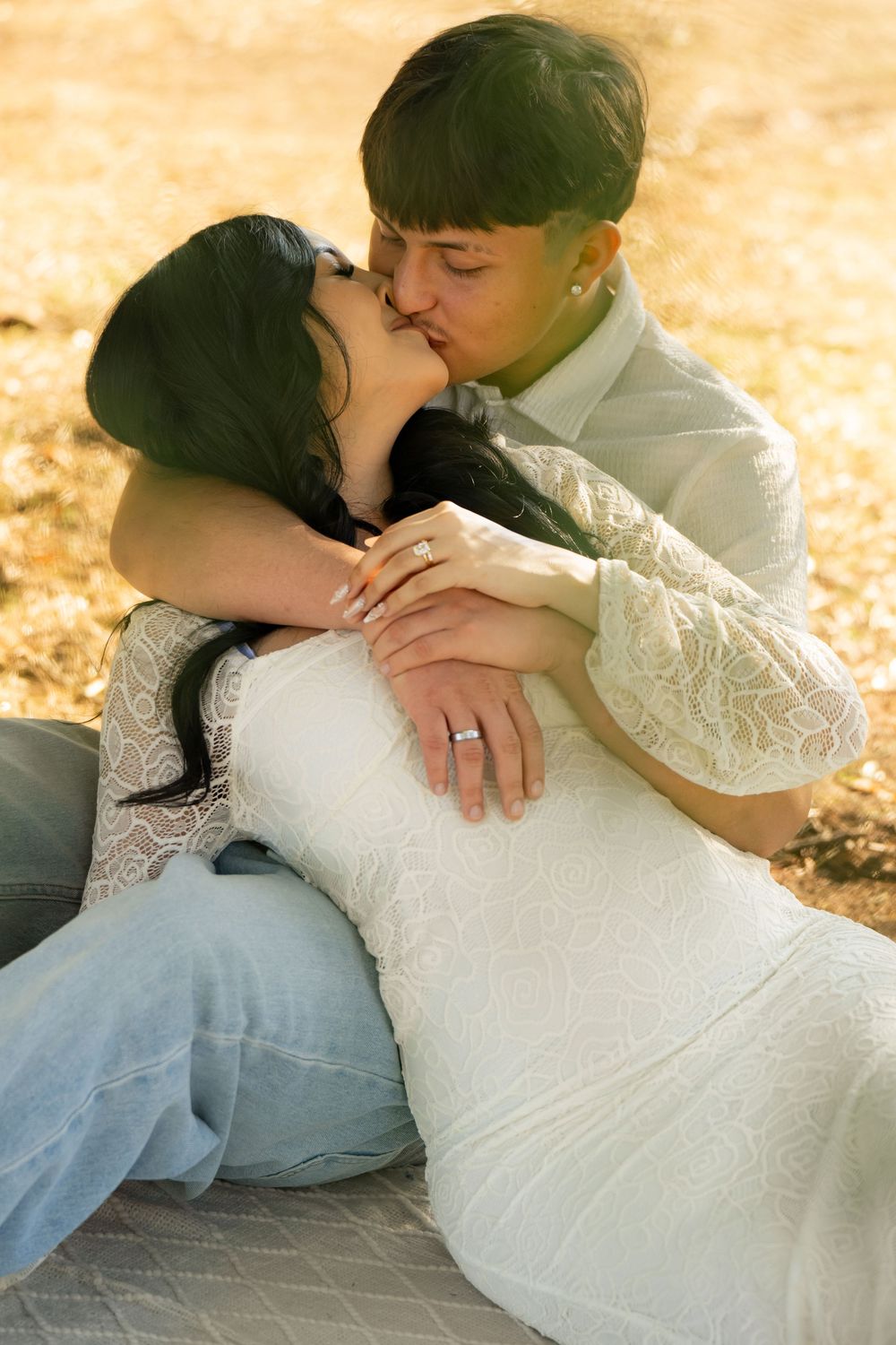 Romantic couple in white lace and denim sharing an intimate moment on a sunny autumn day.