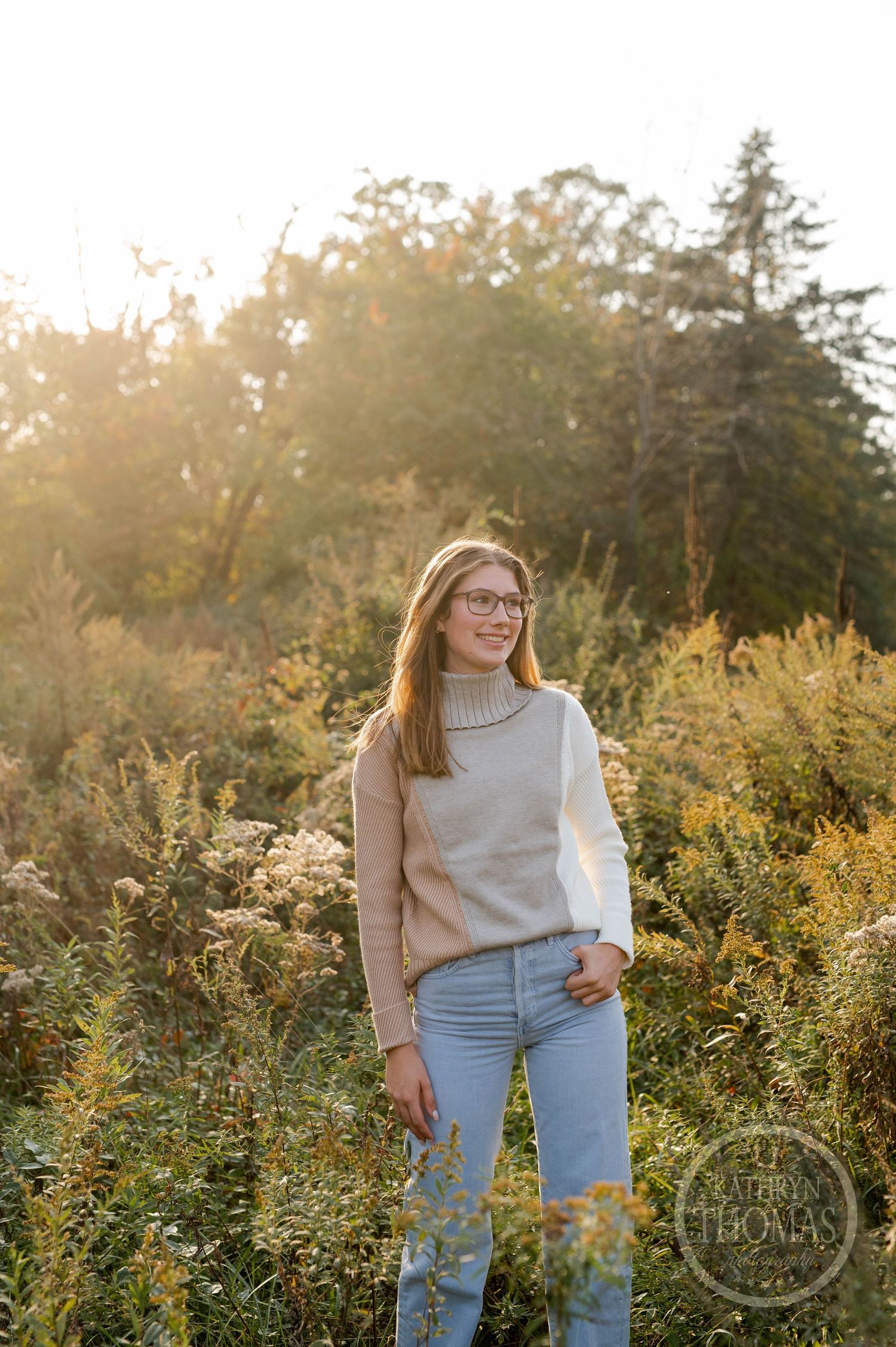 A casual autumn portrait taken in a field of wild golden flowers at sunset.