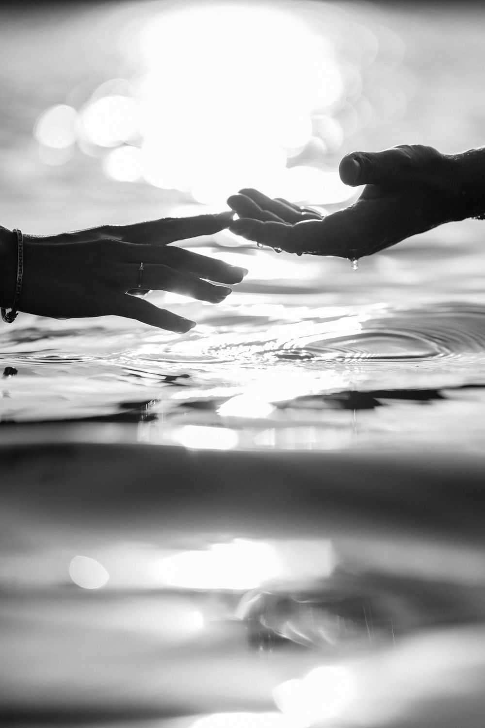 A black and white abstract series of water reflections with rippling patterns and sunlight creating ethereal effects.