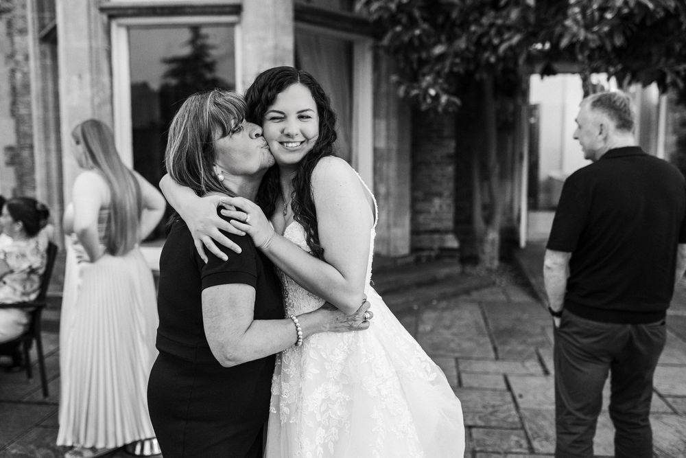 A black and white collage of candid wedding moments showing couples embracing and celebrating together.