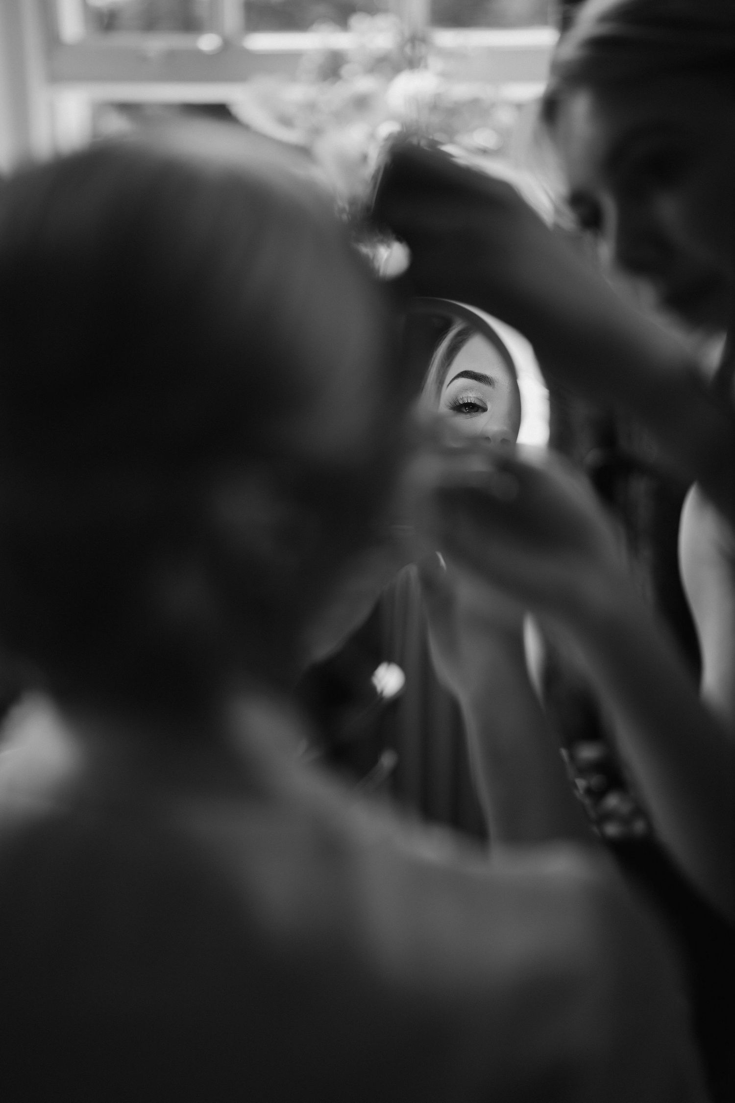 mirror reflection of brides eye while make up artist applied mascara at Iscoyd park