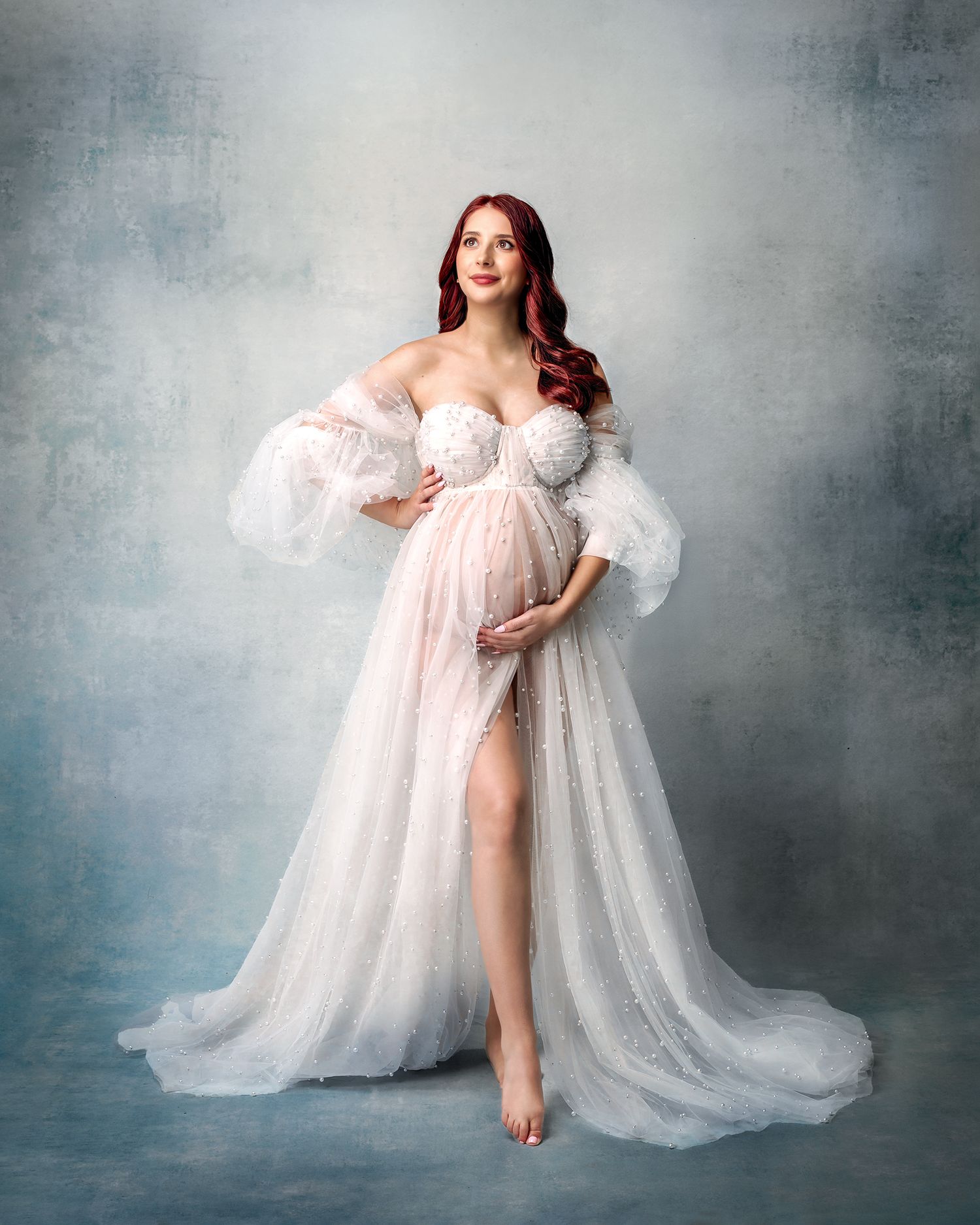 White pearl maternity gown, adding a luxurious texture to the studio photo.