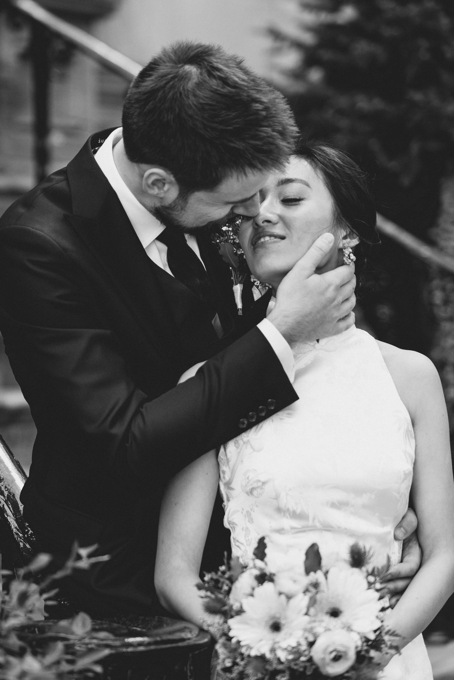 A tender intimate wedding moment captured in black and white with a floral bouquet.