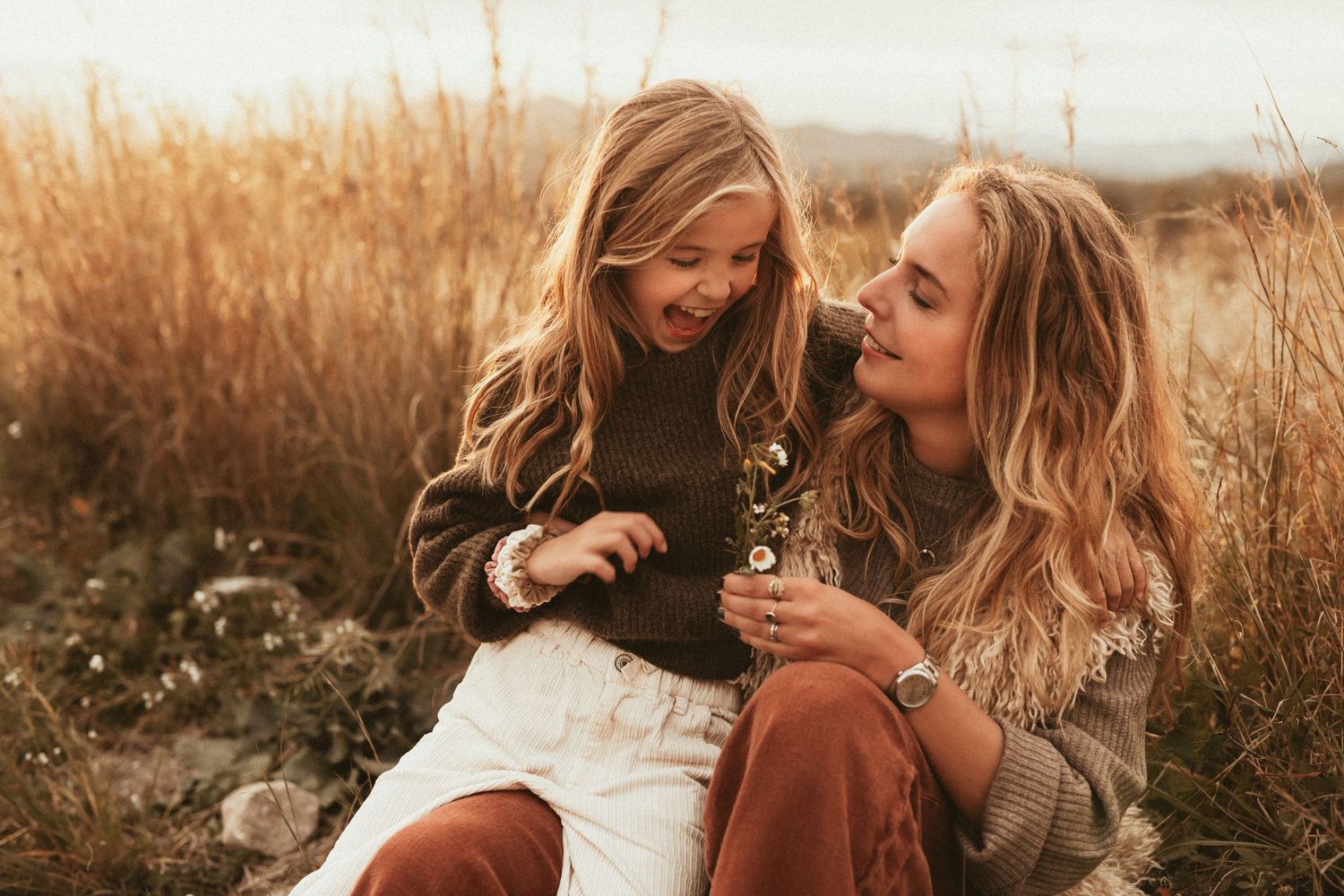 Family session in a grassy field during golden hour sharing a joyful moment together in nature with  Javea photographer