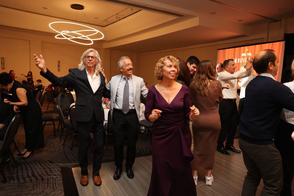 Guests dancing and celebrating at an elegant indoor reception with decorative ceiling lights.