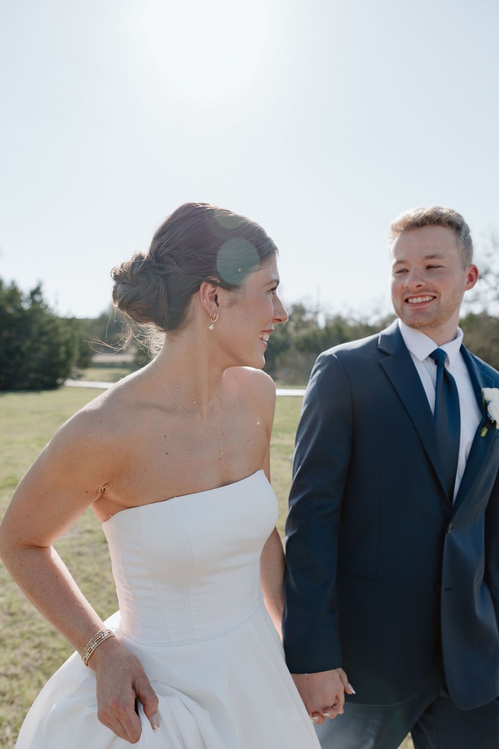 A bride and groom share candid laughing moments together during their outdoor wedding photo session.
