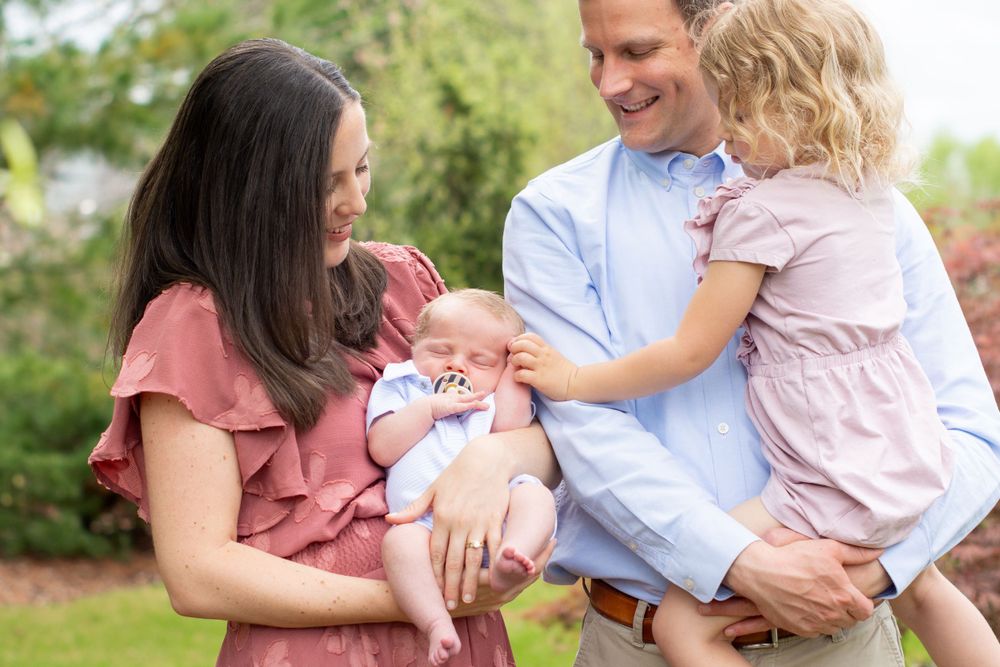 Family enjoying outdoor moment together with newborn baby and toddler.