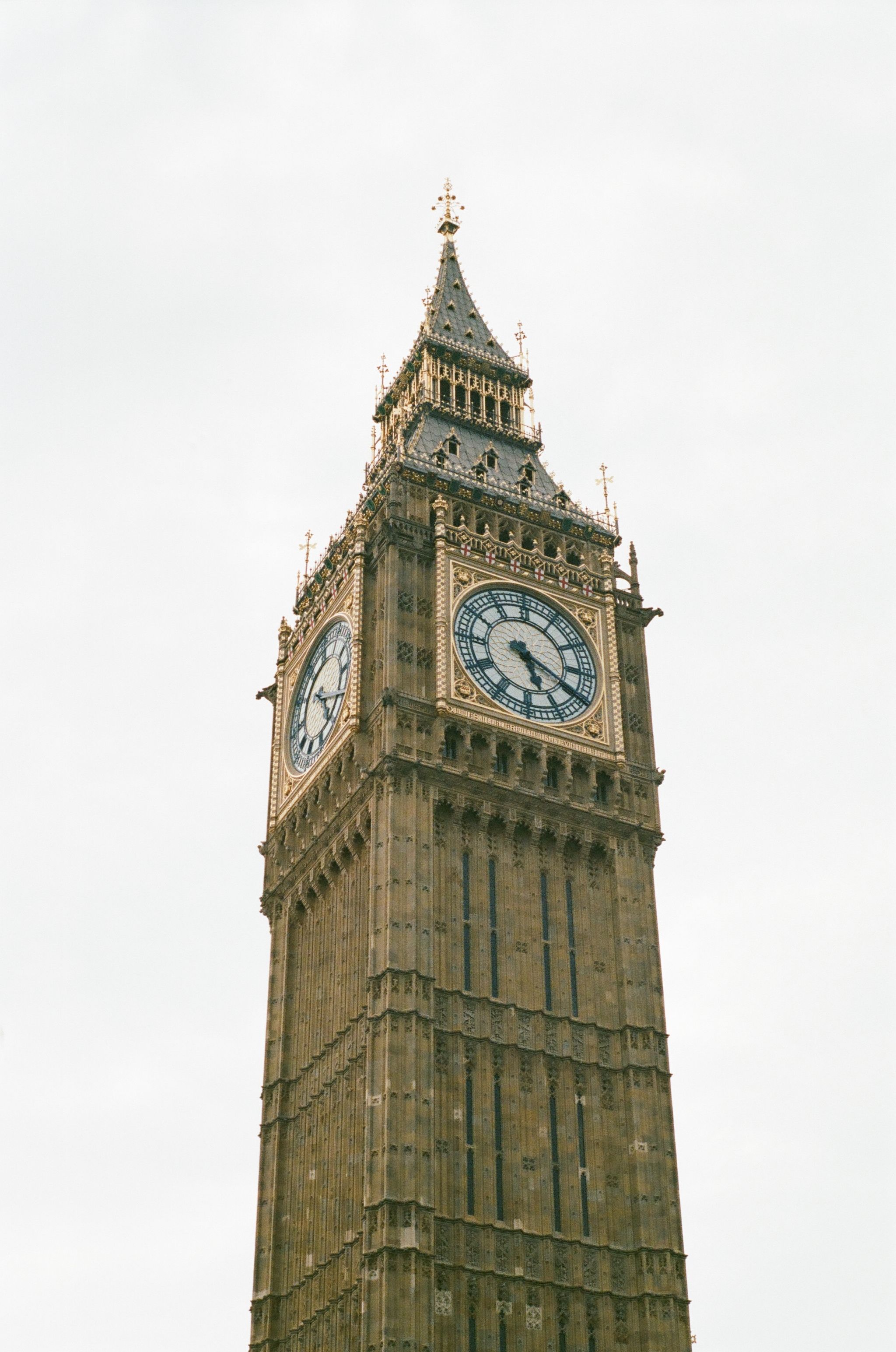 Close-up view of Big Ben's clock tower against cloudy London sky.