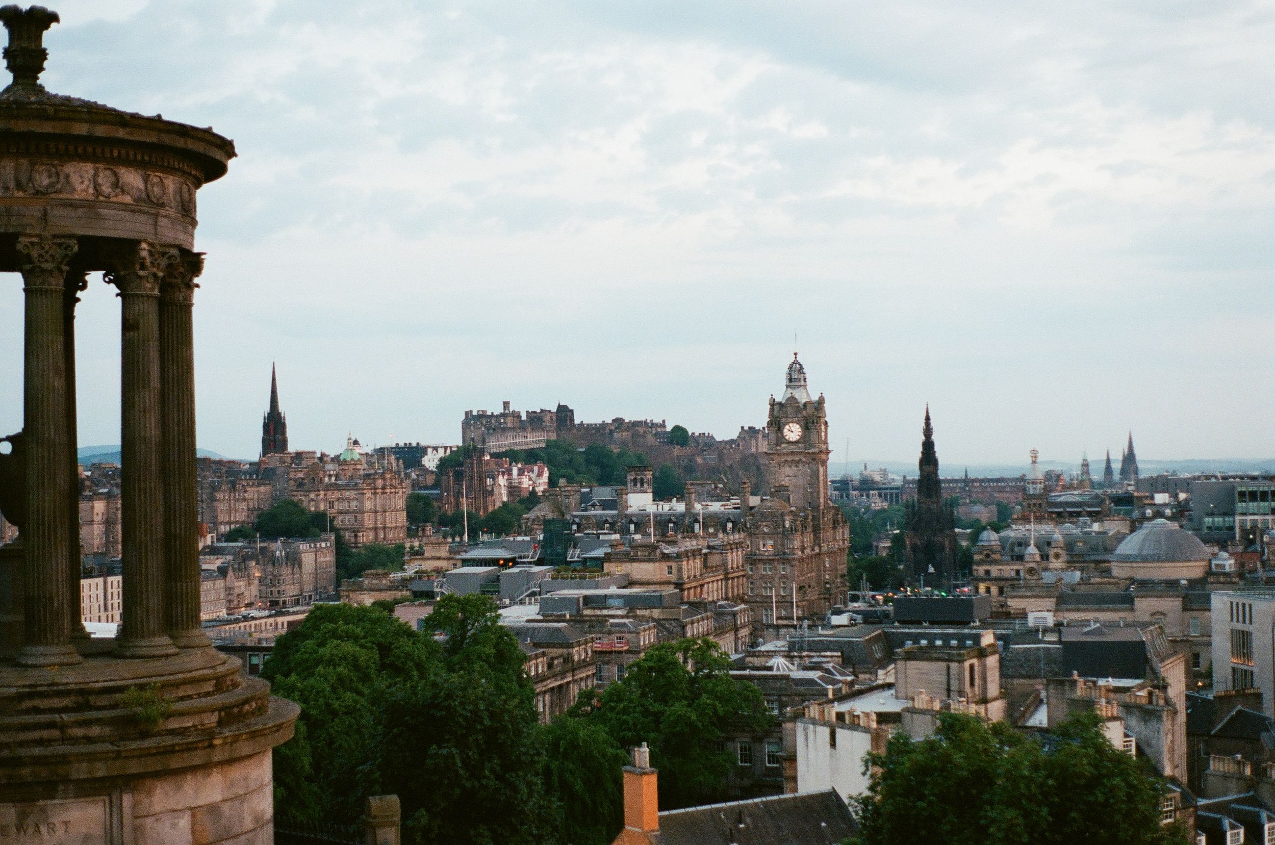 Panoramic cityscape view of Edinburgh's historic skyline with church spires and architecture.