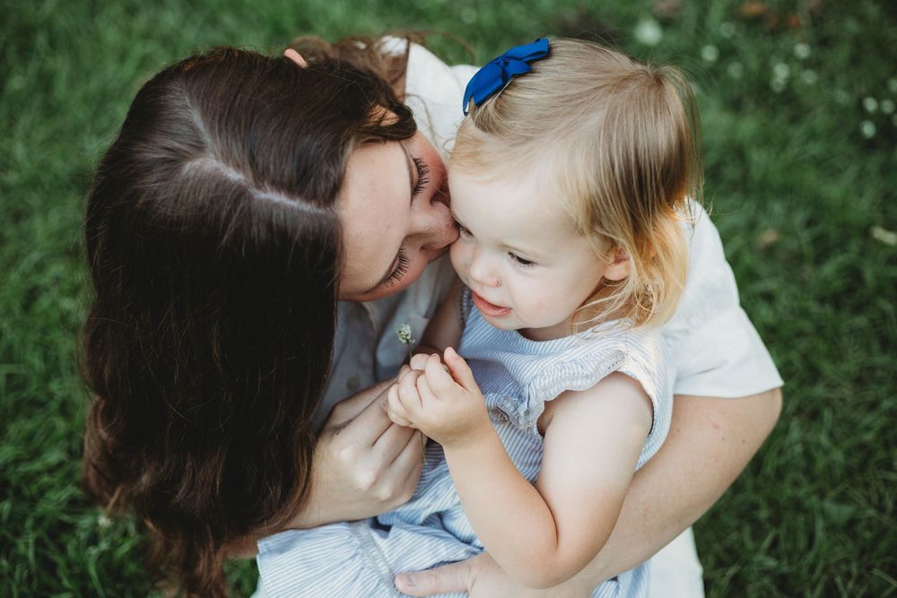 Tender moment between parent and child captured outdoors with natural lighting.