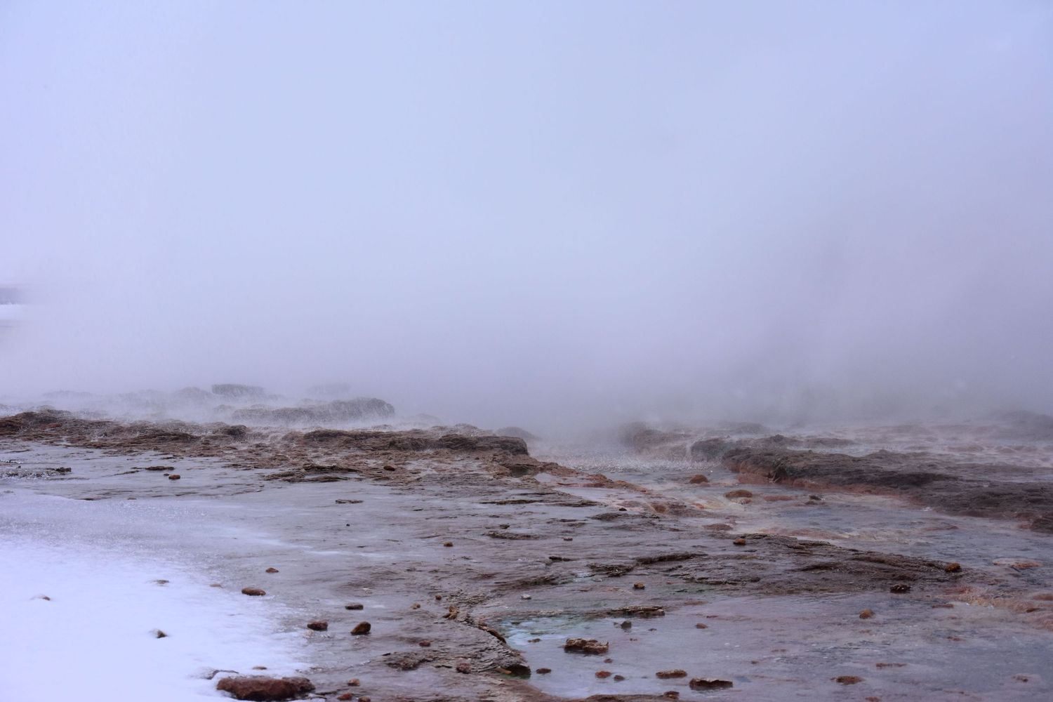 Foggy landscape photograph. rocks and water on the ground.
