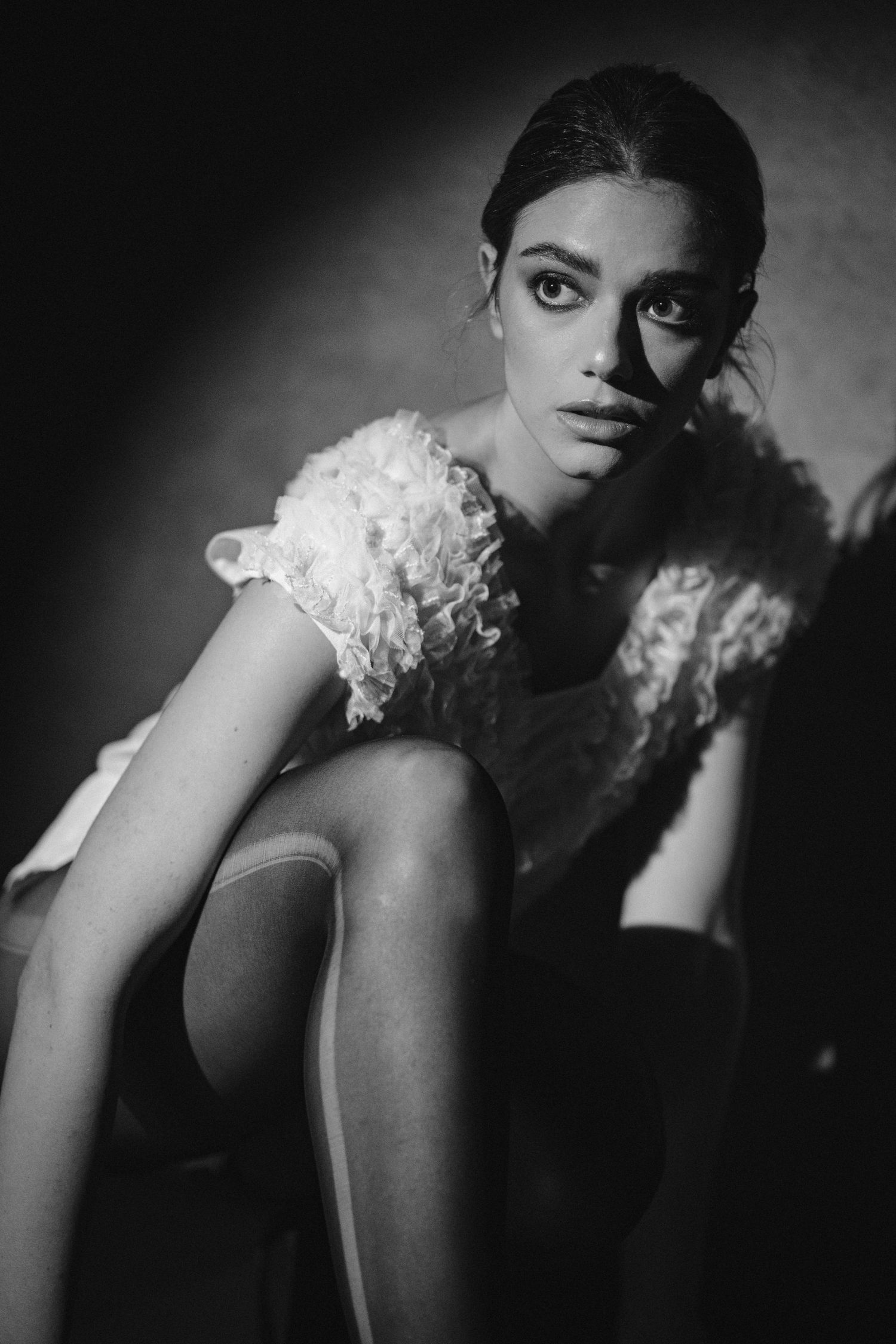 Dramatic fashion portrait in black and white showcasing lace detail and artistic pose.