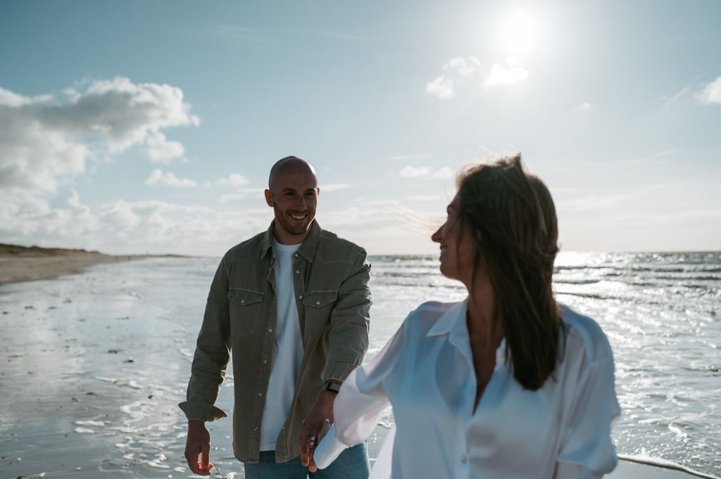 Melissa Stuer Photography Moederschapsfotograaf Moerbeke Zwangerschapsfotograaf koppel die handen vasthouden wandelend op het strand aan zee